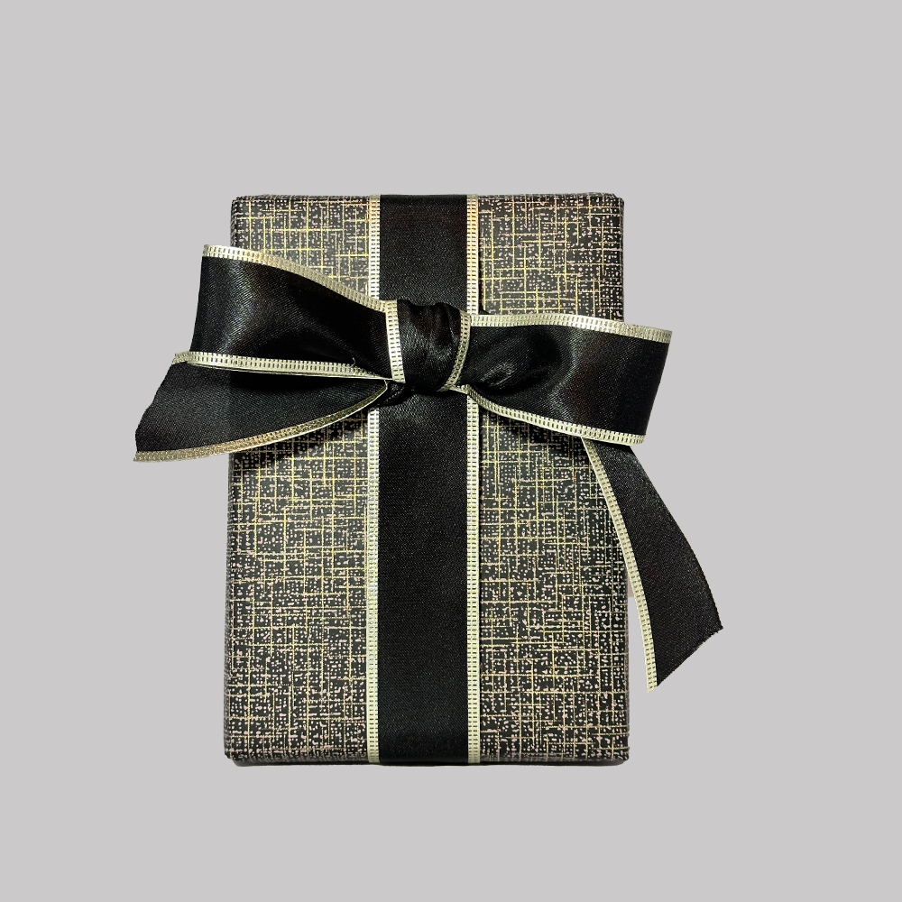 Gift Wrap Option with black and gold patterned wrapping paper and black ribbon with gold edge tied in a bow.